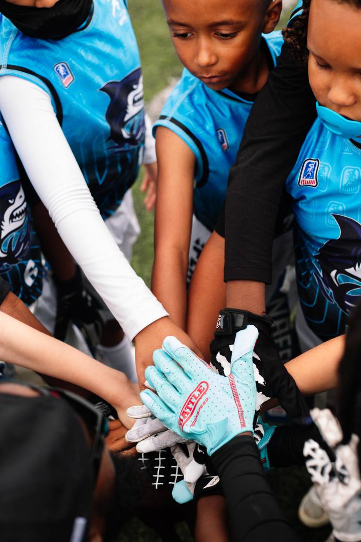 Athletes stacking hands before kickoff