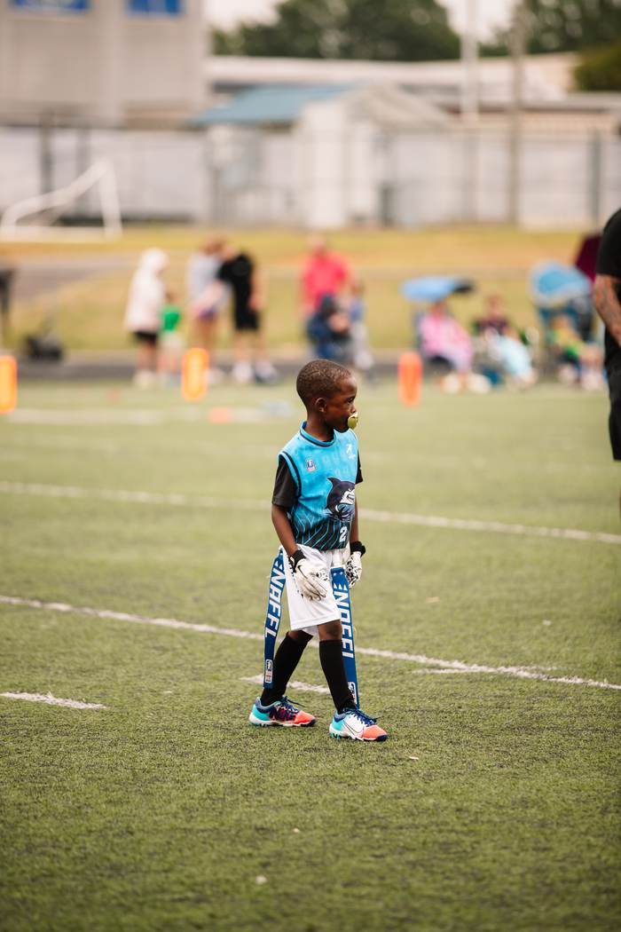 A young Shark walking the field between plays
