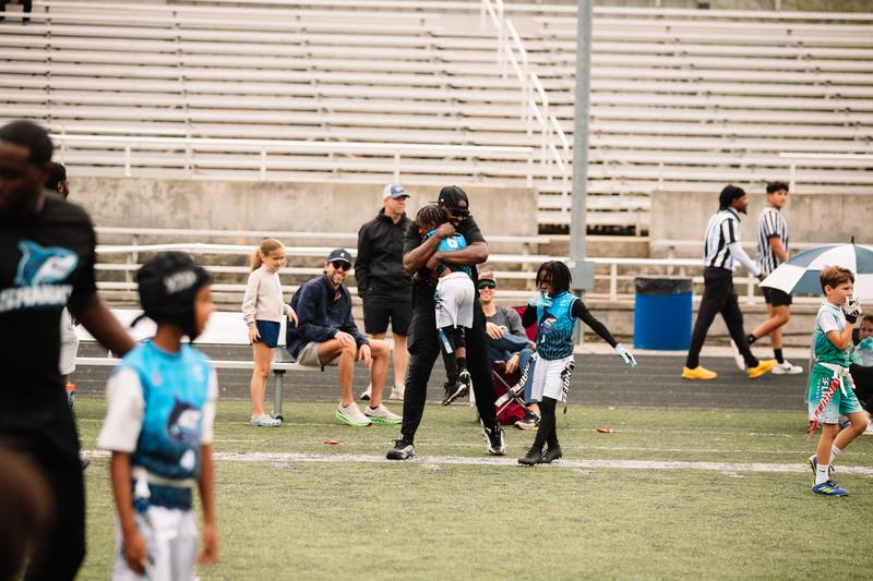 A coach lifting an athlete after a play