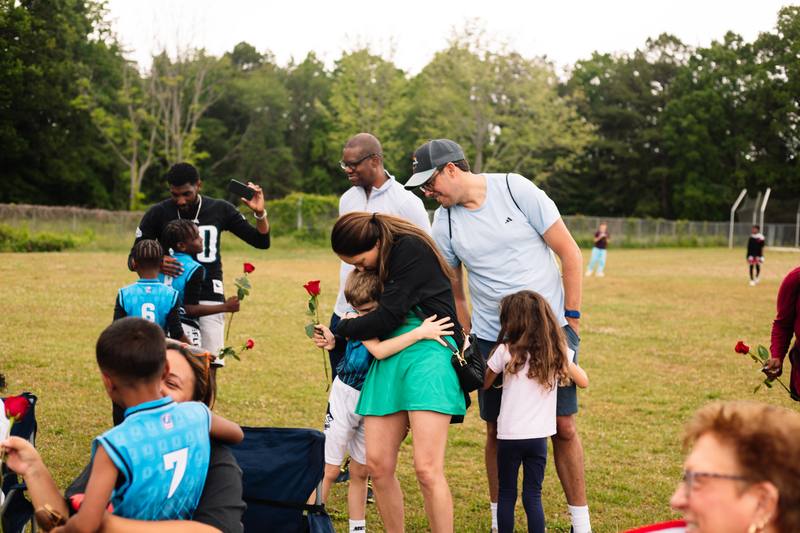 Athletes handing roses to their families after the last game